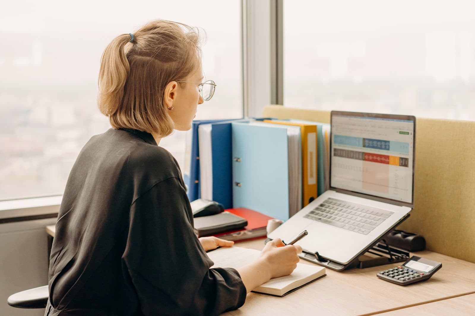 Une dirigeante étudie des tableaux sur son ordinateur portable, à son bureau.