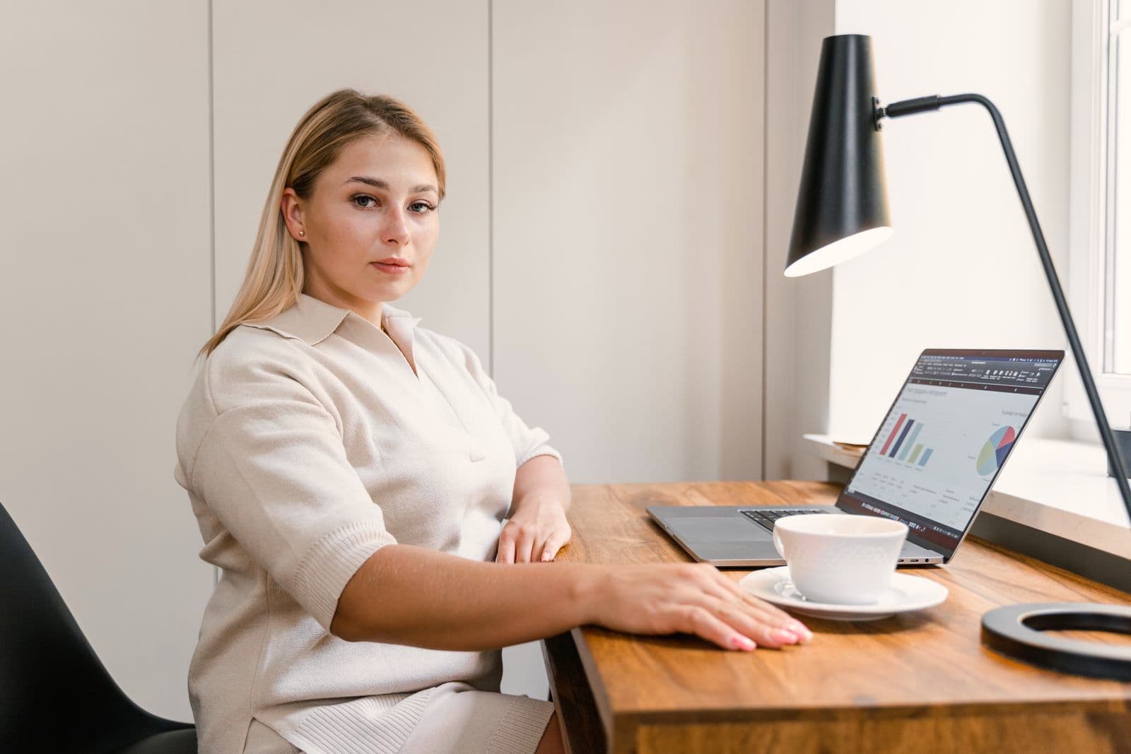 Une cheffe d'entreprise à son bureau, devant son ordinateur portable.