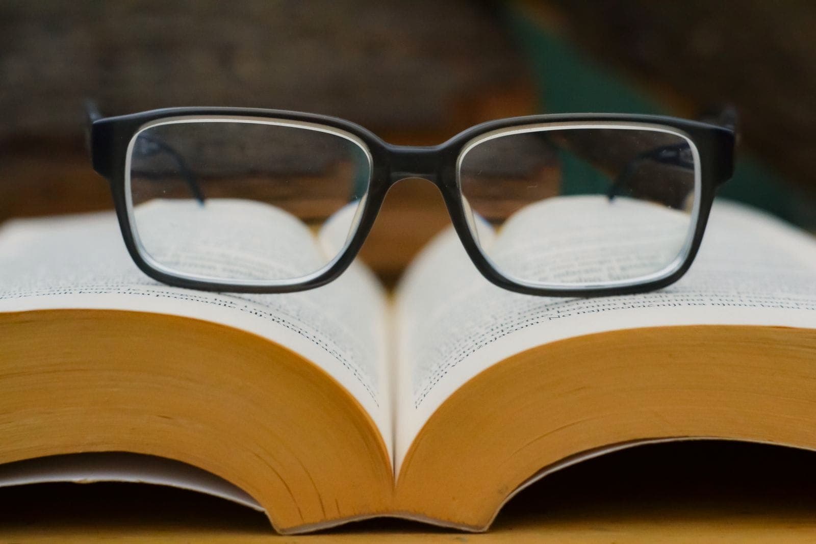 Des lunettes de lecture posées sur un livre ouvert.