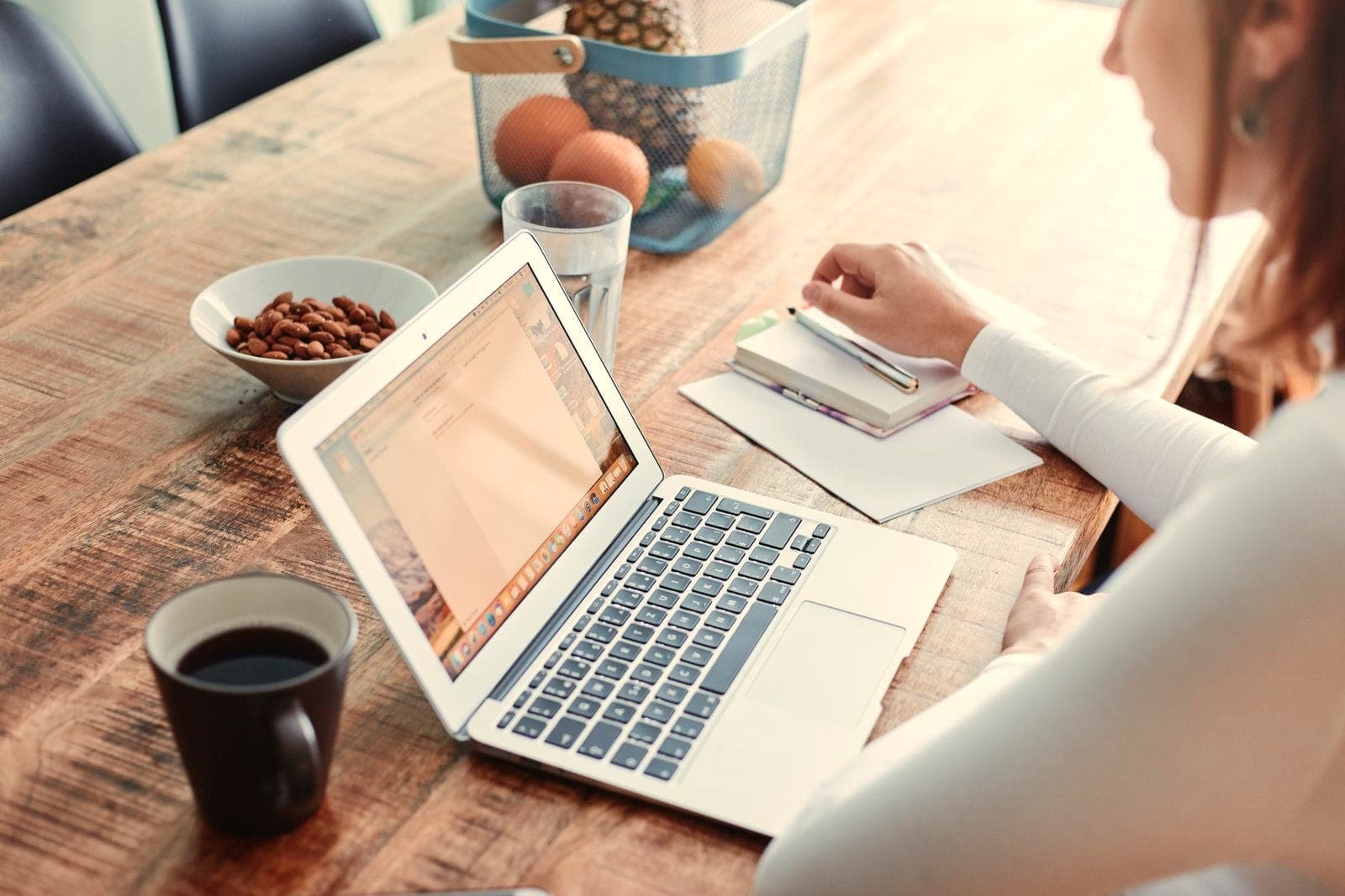 Un ordinateur portable ouvert et une tasse de café sur une table en bois.