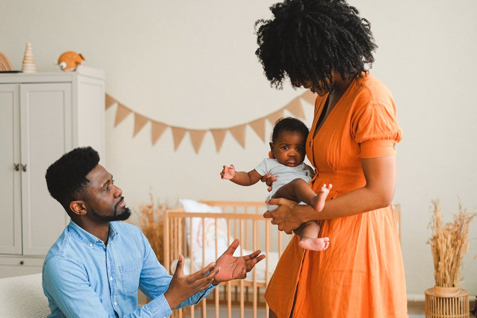 Des parents jouent avec leur bébé dans sa chambre.